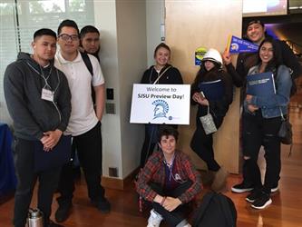 8 students wearing name tags with one holding sign saying Welcome to SJSU Preview Day!